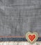 Grey and light grey denim background with a seam and felt heart. Light gray color denim jeans fabric texture