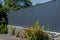 Grey metal corrugated fence in front of a residential building. Texture of profiled metal.