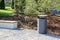 grey minimalist dustbin and wooden Park bench with mulched lands