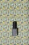 Grey nail lacquer on trendy graphic patterned colorful background.