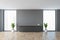 Grey office room with desk near wall, windows and plants in empty business room