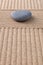 Grey pebble on raked sand vertical