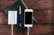 Grey phone and power bank connected by cord with pen and notebook on a wooden background