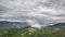 Grey rainy clouds moving over green landscape Aerial Time lapse