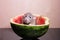 Grey rat sitting in half a watermelon