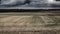 Grey scale shot of an agricultural field under the angry clouds