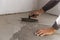 Grey self-leveling screed, new floor layer, man hand