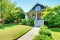 Grey small old American house front exterior with white staircase.