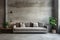 Grey sofa against window in grunge room with concrete walls. Loft home interior design of modern living room
