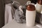 Grey sponge and shower gel bottle on washbasin in bathroom, closeup
