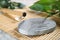 Grey stone coaster with acupuncture needles on bamboo mat