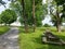 Grey stone house with green grass and trees and picnic tables