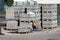 Grey stone tiles and concrete curbs stacked on top of wooden pallets at local construction site