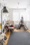 Grey tent,colorful armchair, grey lamp and rug in small kid`s playroom