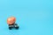 The grey truck car is carrying an orange Easter egg on blue background. Happy Easter holiday, minimalism concept. Greeting,