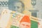 A grey two thousand Indonesian rupiah bank note paired with a orange and green 20 rupee note from Pakistan.