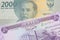 A grey two thousand Indonesian rupiah bank note paired with a purple fifty dinar bill from Iraq.