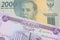 A grey two thousand Indonesian rupiah bank note paired with a purple fifty dinar bill from Iraq.