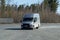 A grey van enters a parking lot near road. Surgut, Russia - 16 April 2021