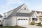 A grey and white home with a pergola awning.