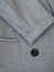 Grey women suit jacket with closeup buttons. Business or formal wear. Gray fabric for tailoring. The grey pinstripe suit