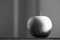 Greyscale of an apple reflecting on the table with a blurry background