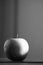 Greyscale of an apple reflecting on the table with a blurry background