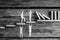 Greyscale image of small paper people holding up falling dominos while standing on wooden steps