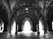 Greyscale shot of an illuminated gothic hall