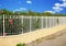 Grid fence in front of a hedge of oleanders in bloom.