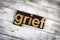 Grief Letterpress Word on Wooden Background