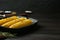 Grill pan with tasty frying corn on dark grey wooden table. Space for text