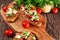 Grilled appetizer bruschettas with tomatoes, mozzarella and parsley sprinkle