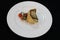 Grilled atlantic cod fish fillet on a white plate with cherry tomato