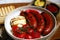 Grilled Bavarian sausages with mozzarella and cherry tomatoes in a plate with sauces