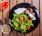 Grilled beaf steak meat with fresh vegetable salad and tomatoes on black plate, wooden background