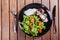 Grilled beaf steak meat with fresh vegetable salad and tomatoes on black plate, wooden background