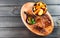 Grilled beaf steak with sauce and potatoes fries in a bucket on wooden cutting board