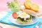 Grilled beef burger with cheese sauce and vegetables