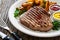 Grilled beef sirloin steak with baked potatoes on wooden table