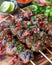 Grilled Beef Skewers with Pomegranate Seeds and Fresh Herbs on Wooden Board, Delicious Barbecue Meal