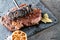 Grilled beef steak fillet with ingredients like sea salt, pepper, onion and metal letters on black board, food background for rest