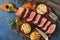 Grilled beef steak medium rare is sliced on a cutting board with spices and baked eggplants. Top view, flat lay. Toned