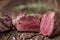 Grilled beef steak with rosemary, salt and pepper on old cutting board. Beef