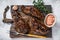 Grilled brisket steaks in bbq sauce on a wooden board. White background. Top view