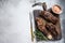 Grilled brisket steaks in bbq sauce on a wooden board. White background. Top view. Copy space