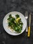 Grilled broccolini with greek yogurt and toasted almonds on a dark background. Delicious breakfast, brunch, snack, appetizer