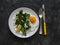 Grilled broccolini with greek yogurt and toasted almonds and fried egg on a dark background. Delicious breakfast, brunch