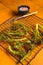 Grilled Broccolini Sprouts with garlic. Orange background. Top view