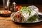 grilled burrito wrapped in silver foil on a wooden table